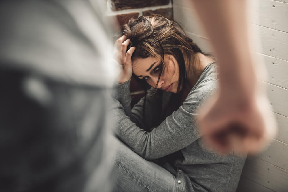 Terrified woman with bruises from sexual assault.